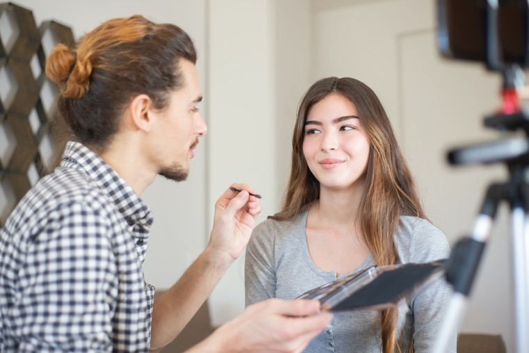 A makeup artist with his client